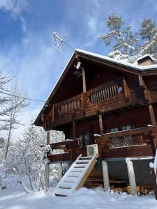 a log cabin in the snow with a snowy roof at Le Mistral Hakuba in Hakuba