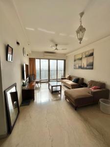 ムンバイにあるSea view with balconyのソファとテーブルのあるリビングルーム