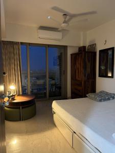ムンバイにあるSea view with balconyのベッドとテーブルと窓のある寝室