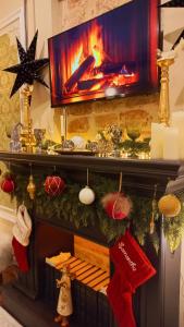 Una chimenea con un televisor encima y adornos navideños. en Deja-View house, en Tiflis