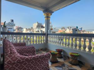 2 sillas en un balcón con vistas a la ciudad en Below The Hills suite WHome Theatre, en Katmandú