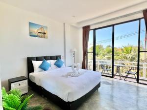 a bedroom with a large bed and a balcony at Serenity by Peace Garden in Amphoe Koh Samui