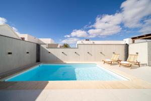 een zwembad aan de zijkant van een huis bij Villa Moon in Tías