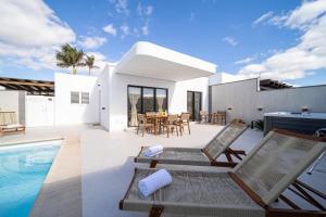 een villa met een zwembad en een huis bij Villa Moon in Tías