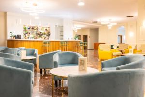 a waiting room with blue chairs and a counter at Hotel Terme Alexander in Ischia