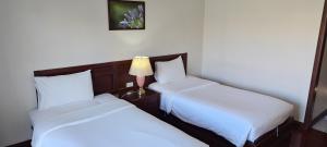 2 letti in una camera con lampada su un tavolo di Puangpen Villa Hotel a Hua Hin