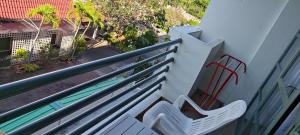 un balcone con una panchina bianca e una piscina di Puangpen Villa Hotel a Hua Hin