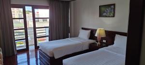 una camera d'albergo con due letti e una finestra di Puangpen Villa Hotel a Hua Hin