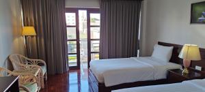 una camera d'albergo con due letti e un balcone di Puangpen Villa Hotel a Hua Hin Altre 92 foto