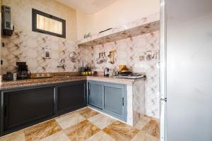 Aero Femme Hostel lit pour femme في مراكش: مطبخ بخزائن سوداء وجدران رخامية