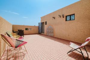 Aero Femme Hostel lit pour femme في مراكش: فناء مع كرسيين ومبنى
