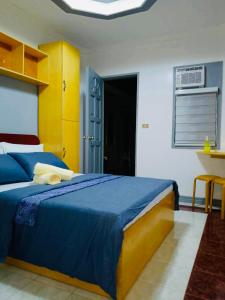 a bedroom with a blue and yellow bed and a window at Z House of Guests 6- Mambago B, Samal Davao Del Norte in Samal