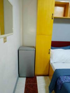 a small room with a bed and a yellow door at Z House of Guests 6- Mambago B, Samal Davao Del Norte in Samal