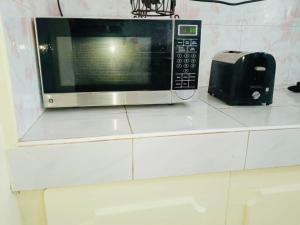a microwave sitting on a counter next to a toaster at Z House of Guests 6- Mambago B, Samal Davao Del Norte in Samal +2 photos
