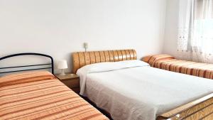 een slaapkamer met 2 aparte bedden en een raam bij Bilocale fronte mare - RM08 in Senigallia +4 foto's