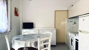 een keuken met een tafel en stoelen in een kamer bij Bilocale fronte mare - RM08 in Senigallia