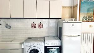 een keuken met een wasmachine en een wasmachine bij Bilocale fronte mare - RM08 in Senigallia