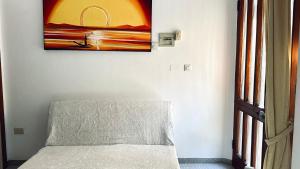 een schilderij hangend aan een muur naast een bank bij Bilocale fronte mare - RM08 in Senigallia