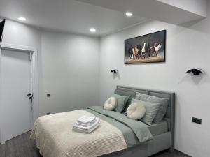 a bedroom with a bed and a picture on the wall at Modern Apartment in Chişinău