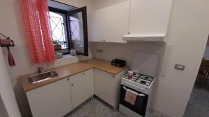 een kleine keuken met een spoelbak en een fornuis bij Laura's Cottage in Calatabiano +12 foto's