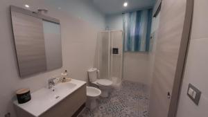 een badkamer met een wastafel, een toilet en een douche bij Laura's Cottage in Calatabiano