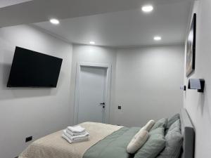 a bedroom with a bed and a flat screen tv at Modern Apartment in Chişinău +2 photos