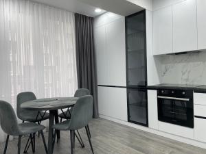 a kitchen with a table and chairs in a room at Modern Apartment in Chişinău