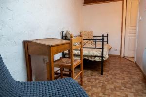 a room with a desk and a bed and a chair at LE MYRO in Péreyres