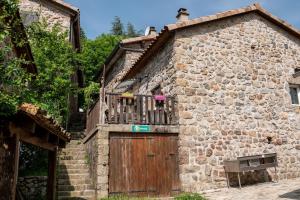 a stone building with a wooden door and a balcony at LE MYRO in Péreyres +7 photos