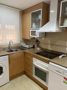 a kitchen with a sink and a stove top oven at Edificio TORREMAR vistas al mar, orientación norte, Wifi y Smart-TV in Oropesa del Mar