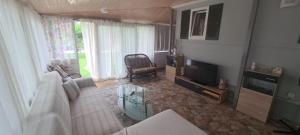 Μια τηλεόραση ή/και κέντρο ψυχαγωγίας στο Beachside Mobile Home with Private Yard