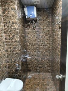 a bathroom with a shower with a toilet in it at Hotel Sky Grand in Guwahati