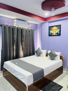Un dormitorio con una cama grande con paredes moradas. en Hotel Sky Grand, en Guwahati