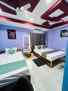 1 dormitorio con 2 camas y paredes moradas en Hotel Sky Grand, en Guwahati 11 fotos más