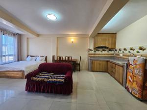 a bedroom with a bed and a couch and a kitchen at The Abode in Kathmandu