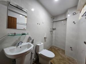a white bathroom with a toilet and a sink at The Abode in Kathmandu +44 photos