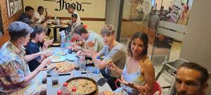 Cactus reef في آهانغاما: مجموعة من الناس يجلسون على طاولة يأكلون البيتزا