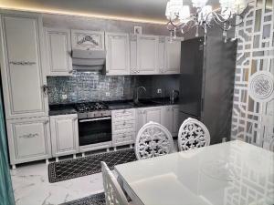 Villa في Gidignitsy: مطبخ مع خزائن بيضاء وطاولة وكراسي +18 صورة