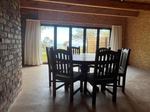 una sala da pranzo con tavolo e sedie e un muro di mattoni di Unique Farm Stay a Seafield