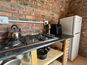 una cucina con piano cottura e muro di mattoni di Unique Farm Stay a Seafield Altre 3 foto