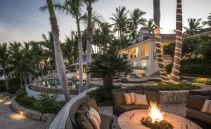 a resort with a fire pit and palm trees at Casa Edwards in San José del Cabo