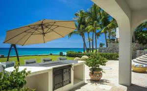 an outdoor kitchen with an umbrella and the beach at Casa Edwards in San José del Cabo