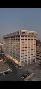 a large white building with cars parked in a parking lot at سكينة هاوس in Riyadh