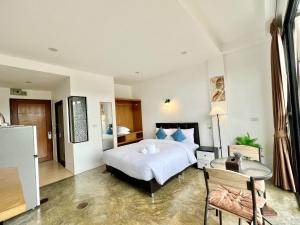a bedroom with a bed and a desk and a table at Serenity by Peace Garden in Amphoe Koh Samui