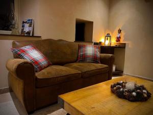 a living room with a brown couch and a wooden table at Haut Charmes de Cornil in Cornil +19 photos