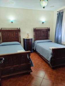 una camera da letto con due letti e un lampadario di Casa Rural Ivanrey a Ivanrey