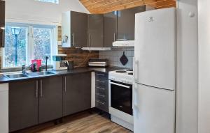 a kitchen with a white refrigerator and a sink at 3 Bedroom Amazing Home In Hallaröd in Hallaröd