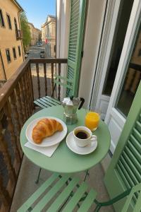 Casa PORTA LANERO di Francesco e Alessandro في نيتسا مونفيراتو: طاولة مع فنجان قهوة وكرواسون