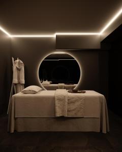 a dark room with a bed with a mirror at The Hotel Paris & SPA in Chişinău