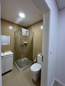 a bathroom with a shower and a toilet and a sink at In Barcelos View Lodge in Barcelos +18 photos